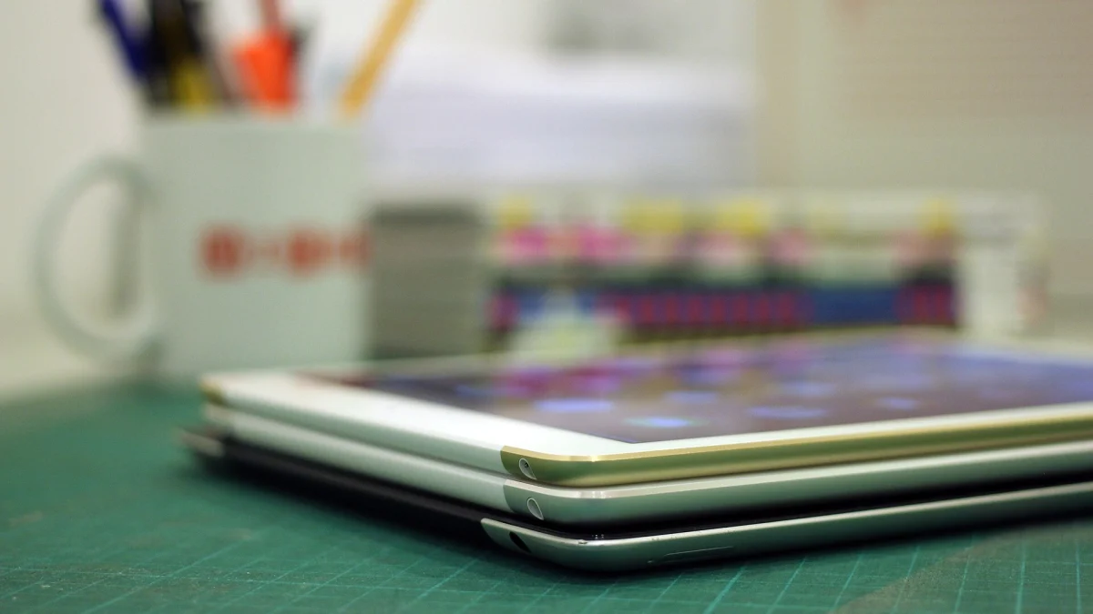 Trois iPad de générations différentes empilés sur un bureau