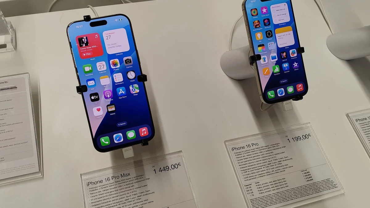 Deux iPhone 16 Pro exposés sur des supports dans un magasin, avec leurs étiquettes de prix